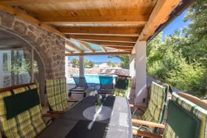 a patio with a table and chairs on a deck at Villa Diamond - Muraj Krk in Kornić