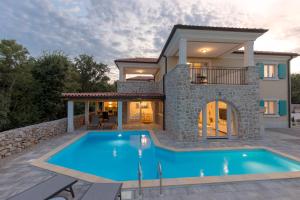 a villa with a swimming pool in front of a house at Villa Diamond - Muraj Krk in Kornić