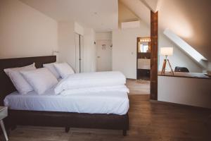 a bedroom with a large bed with white sheets at HDC Nivelles Grand-Place in Nivelles