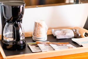 a coffee maker sitting on top of a wooden table at Larian Motel in Tombstone