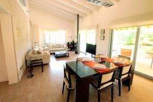 ein Wohnzimmer mit einem Esstisch und einem Wohnzimmer in der Unterkunft Mallorca Villa Bon Aire Son Bernat in Llubí