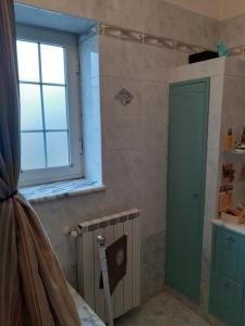 a bathroom with a shower with a green door and a window at CAMERA DELL' ARCO ROMANO in Pozzuoli