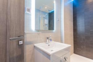 ein Badezimmer mit einem weißen Waschbecken und einem Spiegel in der Unterkunft Cosy and modern apartment HEART OF BELFAST in Belfast + 46 Fotos