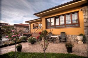 a house with a patio with chairs and flowers at Hospederia Los Pinos in Llanes