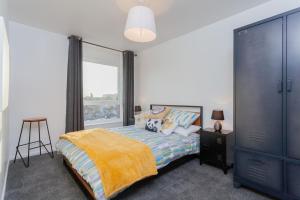ein Schlafzimmer mit einem Bett und einem großen Fenster in der Unterkunft Cosy and modern apartment HEART OF BELFAST in Belfast