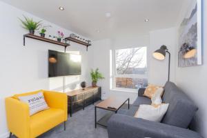 ein Wohnzimmer mit Sofa und Fernseher in der Unterkunft Cosy and modern apartment HEART OF BELFAST in Belfast