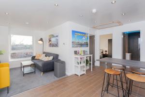 ein Wohnzimmer mit Sofa und Tisch in der Unterkunft Cosy and modern apartment HEART OF BELFAST in Belfast