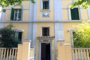 a yellow and white house with a gate and a door at Roma Ostia 100 mt sea in Lido di Ostia
