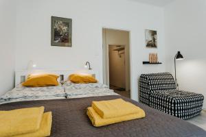 una camera da letto con un letto con coperte gialle e una sedia di Charming apt Old Town & Jewish District, quiet neighborhood a Cracovia