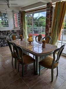 a dining room table with chairs and a vase on it at charmant appartement gondeau jambette in Saint-Joseph +11 photos