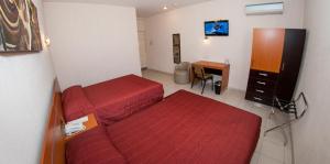a bedroom with a red bed and a desk at Hotel Interforum in León