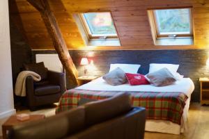 a bedroom with a bed and a chair and windows at Maison d'hôtes La Bageatière - Lac d'Aiguebelette in Lepin-le-Lac +38 photos