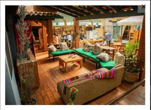 um pátio exterior com sofás e mesas e pessoas num restaurante em Greenhouse Bolivia em La Paz