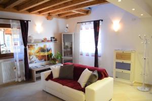 ein Wohnzimmer mit einem weißen Sofa und einem Fenster in der Unterkunft Casa Vacanza CADORNA RESIDENCE in Tarvis