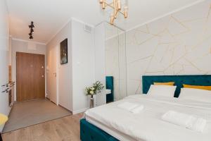 sypialnia z dużym łóżkiem z niebieskim zagłówkiem w obiekcie Warsaw To Be - Golden Apartment w Warszawie