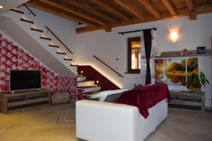ein Wohnzimmer mit einer weißen Couch und einer Treppe in der Unterkunft Casa Vacanza CADORNA RESIDENCE in Tarvis