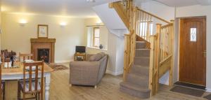 a living room with a staircase with a couch and a fireplace at Finest Retreats - 2 Bed Llangollen Cottage - Sleeps 4 in Llangollen