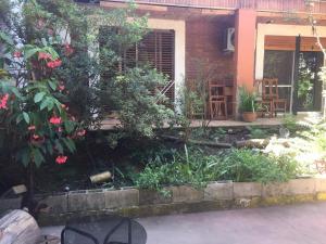 a garden in front of a house with flowers at Hostel Casa & Campo in Buenos Aires