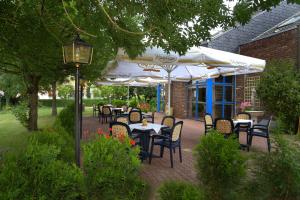a patio with tables and chairs and umbrellas at Hotel Brandenburger Hof in Seelow