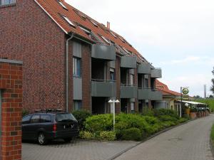 een auto geparkeerd voor een bakstenen gebouw bij Inselstrand in Horumersiel