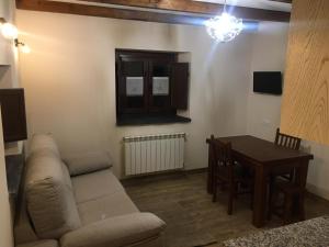 a living room with a couch and a table at La Casa Vieja de Caneo - APARTAMENTOS RURALES 3 llaves in Luarca