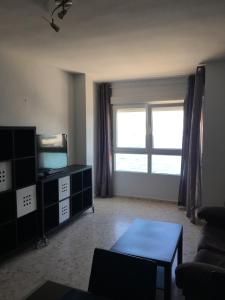 sala de estar con ventana grande y mesa en Bonito Apartamento frente al mar, en Ceuta