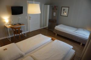 a room with two beds and a table and a desk at Hotel "Zur Moselterrasse" in Palzem