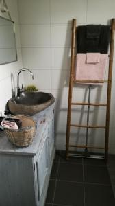 baño con lavabo y escalera de madera en Chalet peter, en Limmen