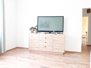 a television on a wooden dresser in a living room at Mieszkanie na Krótkiej in Stronie Śląskie