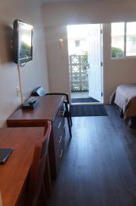 Habitación con escritorio, cama y TV. en Westward Inn & Suites, en Langley