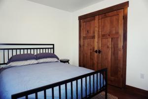 a bedroom with a bed and a wooden door at Silver Birch Vacation Rental in Talkeetna