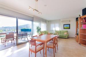 Club Villamar - Veruma في ماسانيت دي لا سيلفا: غرفة معيشة مع طاولة وكراسي خشبية