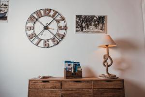 a clock on a wall above a dresser with a lamp at Dimora Antica Perla in Fasano +28 photos