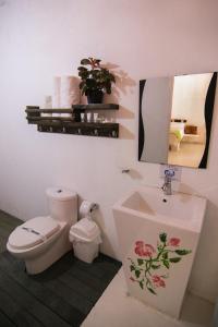 a bathroom with a toilet and a sink and a mirror at Hotel Boutique Yararaka in Villavieja