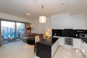 a kitchen and living room with a couch and a table at Westminster Dubai Marina in Dubai