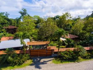 a garden with a wooden fence and trees at Casa Marcellino Lodge in Cahuita