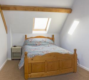 a bedroom with a wooden bed in a attic at Finest Retreats - 2 Bed Llangollen Cottage - Sleeps 4 in Llangollen