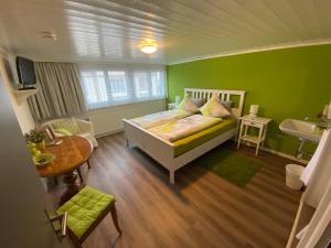 ein grünes Schlafzimmer mit einem Bett und einem Waschbecken in der Unterkunft Gasthaus Sternen in Degersheim