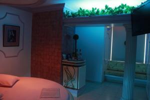 a bedroom with a bed and a bathroom with a tub at Motel Le Plaisir in Salvador