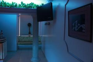 a living room with a television on a wall at Motel Le Plaisir in Salvador