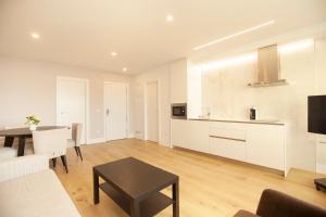 a living room with a kitchen and a table at Apartamentos Reina Victoria in Santander