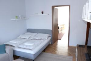 um quarto branco com uma cama e um sofá em Petofi Apartman em Szeged