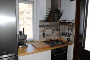 a kitchen with a counter with a stove and a window at Petofi Apartman in Szeged