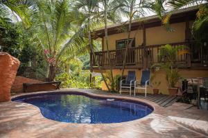 una piscina davanti a una casa di Roatan Backpackers' Hostel a Sandy Bay