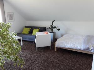 ein Wohnzimmer mit einem Sofa und einem Bett in der Unterkunft Ferienwohnung INGRID in Markt Erlbach