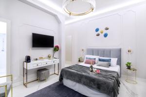 sypialnia z łóżkiem, biurkiem i telewizorem w obiekcie Roma Deluxe Apartments w Rzymie