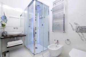 łazienka z przeszkloną kabiną prysznicową i umywalką w obiekcie Roma Deluxe Apartments w Rzymie +28 zdjęć