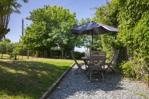 una mesa y sillas bajo una sombrilla en un patio en Finest Retreats - 2 Bed Llangollen Cottage - Sleeps 4, en Llangollen