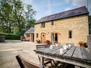 a wooden table in front of a brick building at Little Barn in Cherington