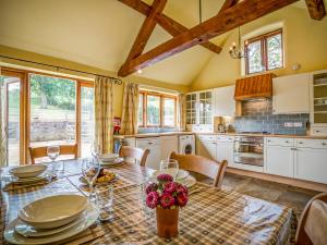 a kitchen with a table with plates and flowers on it at Little Barn in Cherington